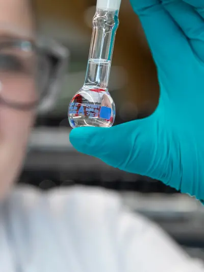Scientist examining clear liquid in volumetric flask