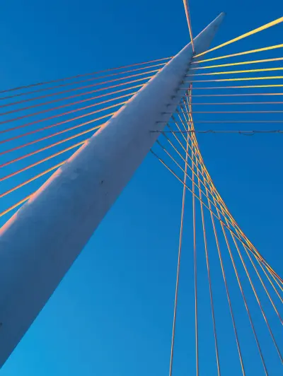Close-up of suspension bridge cables against blue sky