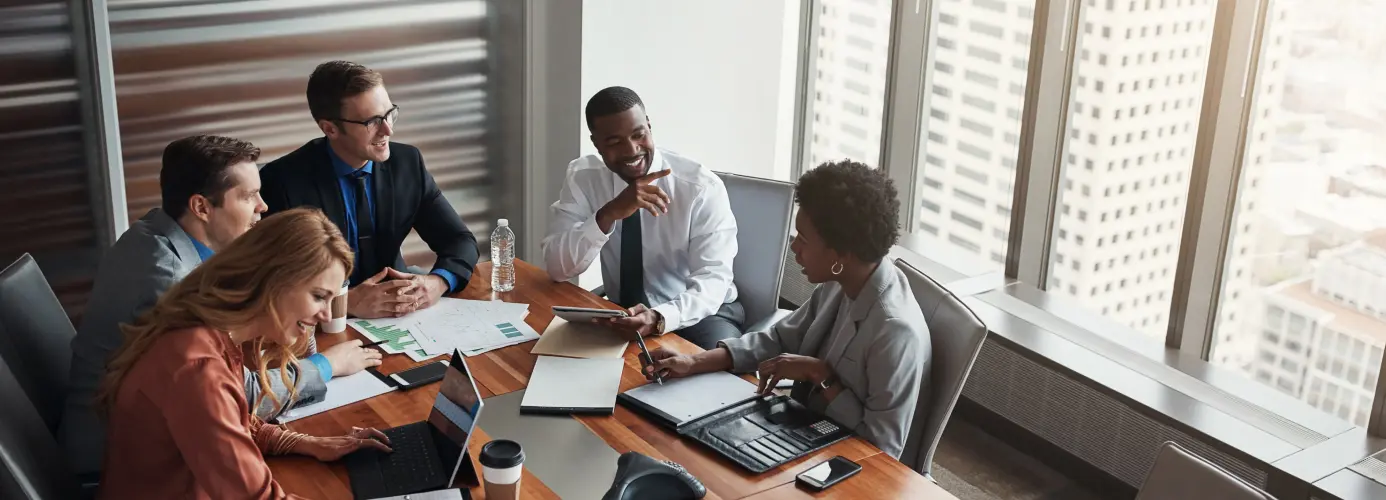 Business meeting with team members discussing around a conference table