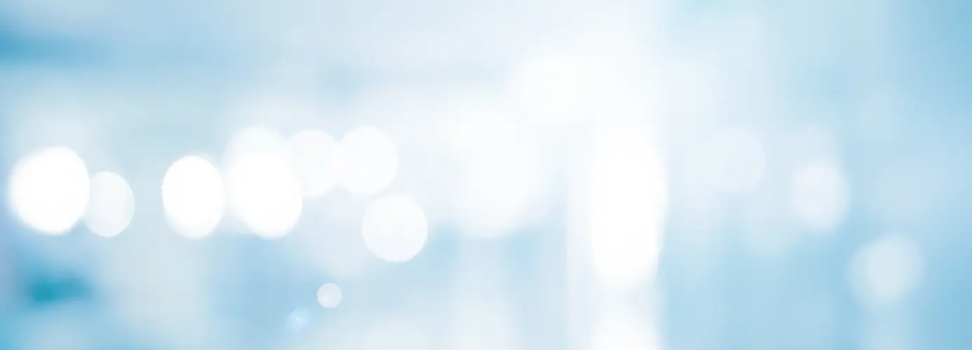 Abstract image with blurry white circles on a light blue background.