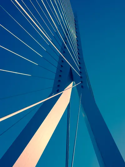 Close-up of suspension bridge cables against blue sky