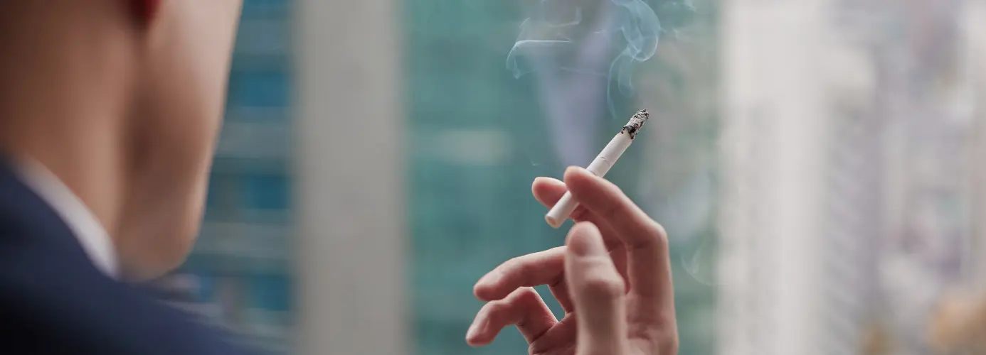 Hand holding lit cigarette