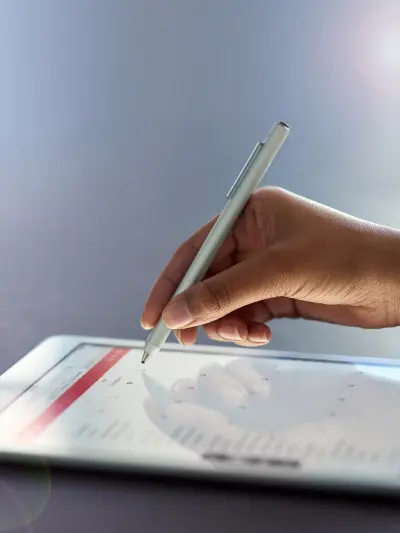 Hand using stylus on tablet screen