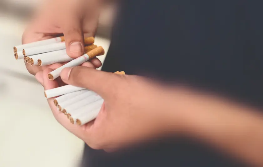 Hands holding multiple cigarettes