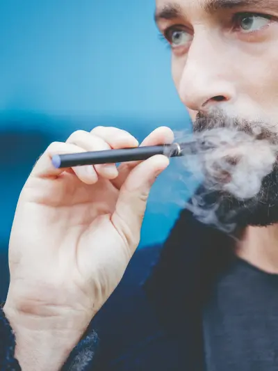 Person exhaling vapor from an e-cigarette