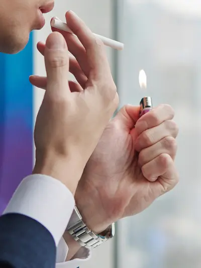 Hands lighting a cigarette with a lighter