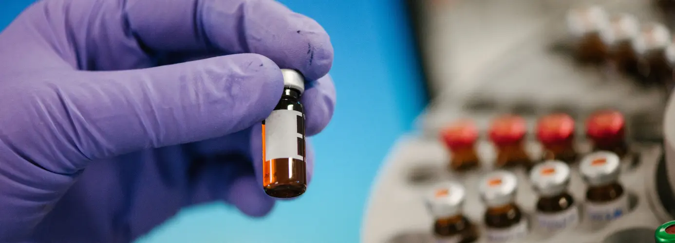 Hand holding small medicine vial