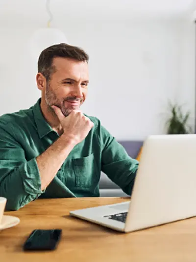 Man in green shirt working on laptop