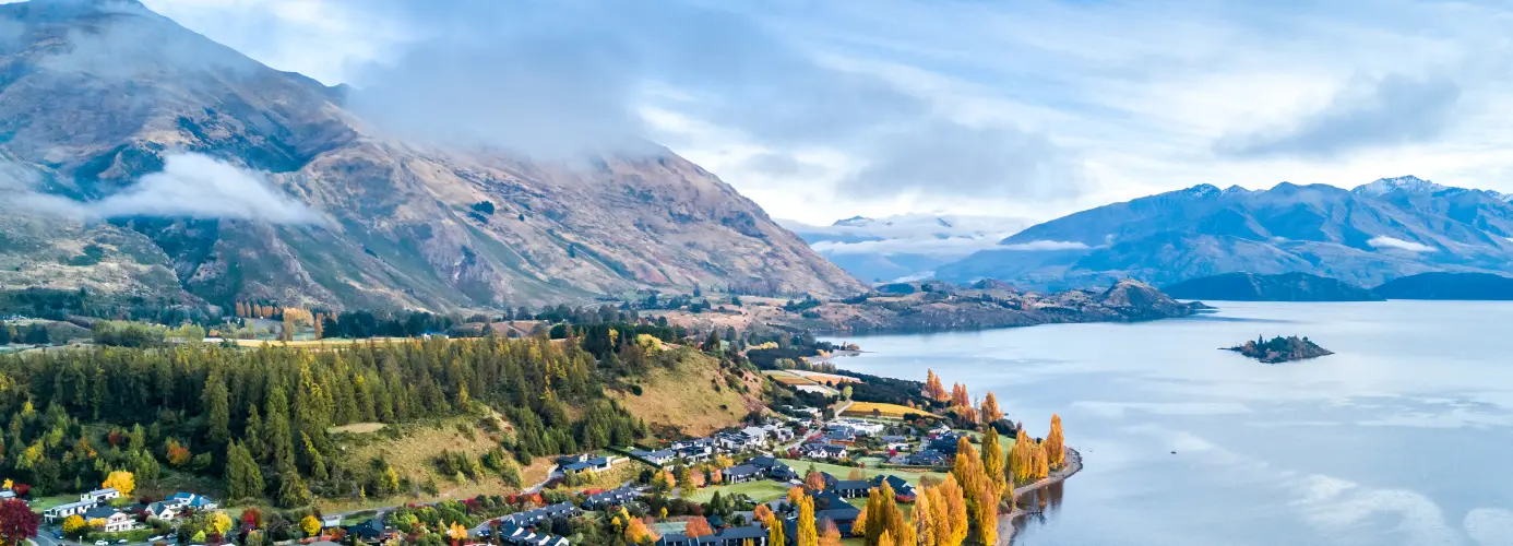 Scenic view of a lakeside town surrounded by mountains in New Zealand.
