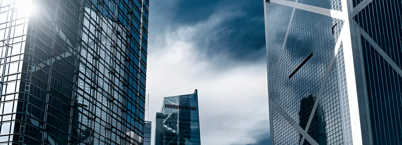 Modern glass skyscrapers against cloudy sky