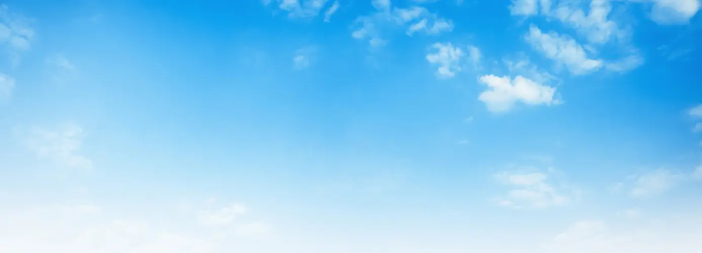 Blue sky with scattered white clouds.