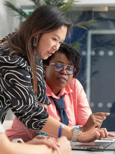Two women collaborating on laptop