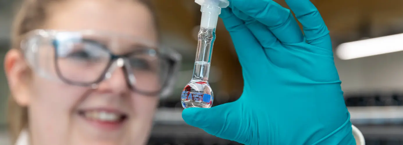 Scientist examining clear liquid in volumetric flask
