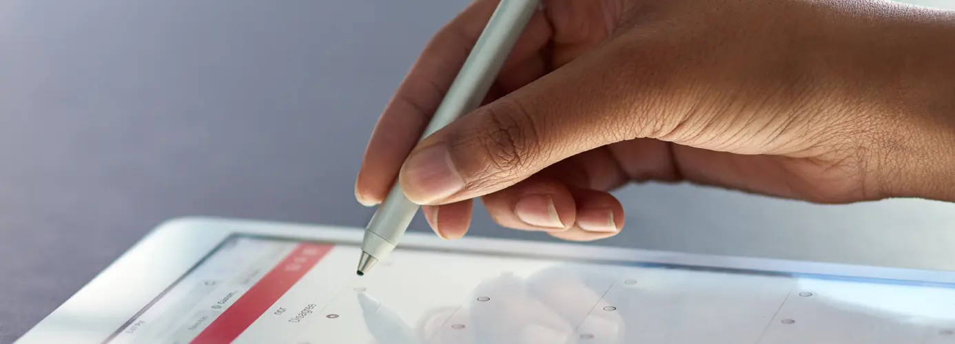 Hand using stylus on tablet