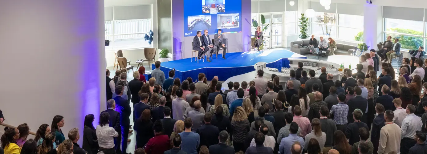 Corporate presentation with speakers on stage and large audience