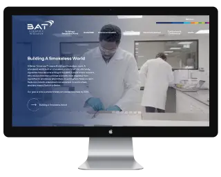 Computer monitor displaying BAT company website with scientists working in a laboratory.