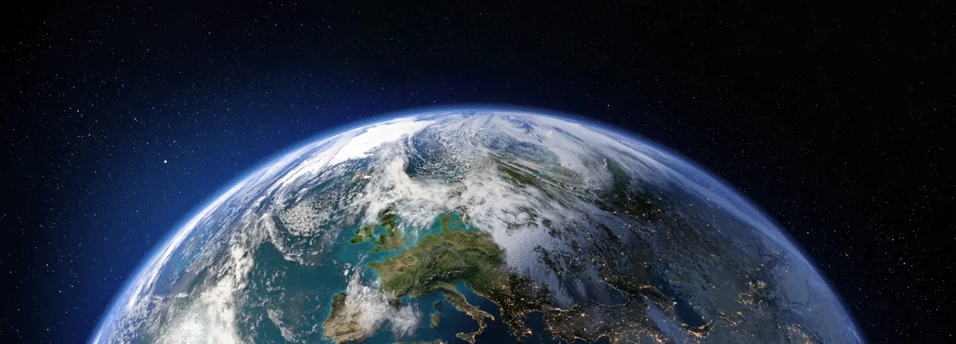 View of Earth from space, showing Europe and part of North Africa, with cloud cover and the curve of the planet visible against a starry background.